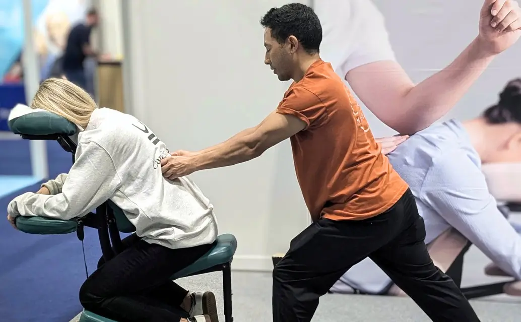 Mobile massage therapist giving exhibition massage as a brand activation to boost visitors.